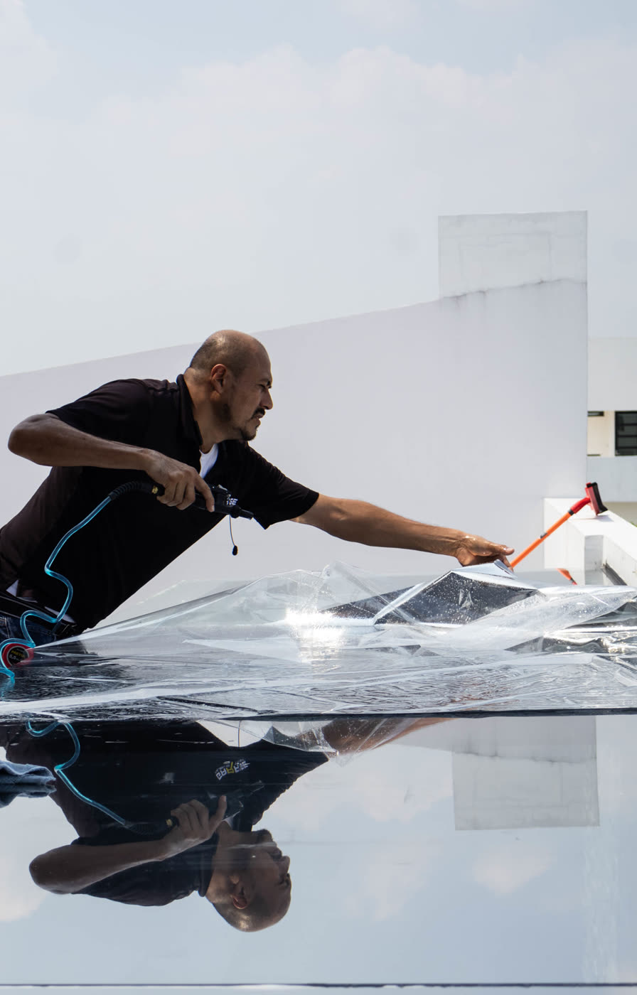 Instalador aplicando película exterior sobre un domo
